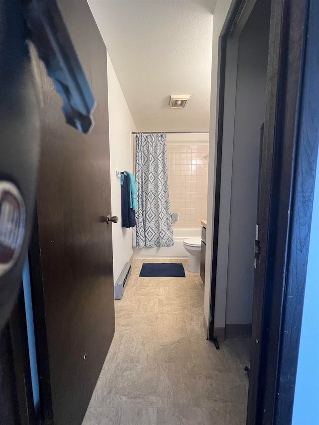 bathroom featuring shower / tub combo, a baseboard heating unit, and toilet