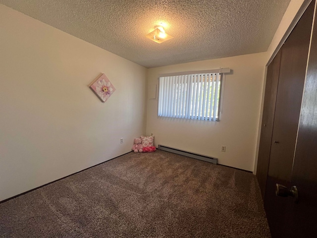 unfurnished bedroom with a closet, a baseboard heating unit, a textured ceiling, and carpet floors