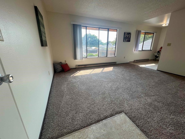 spare room featuring a healthy amount of sunlight, carpet flooring, and a baseboard heating unit