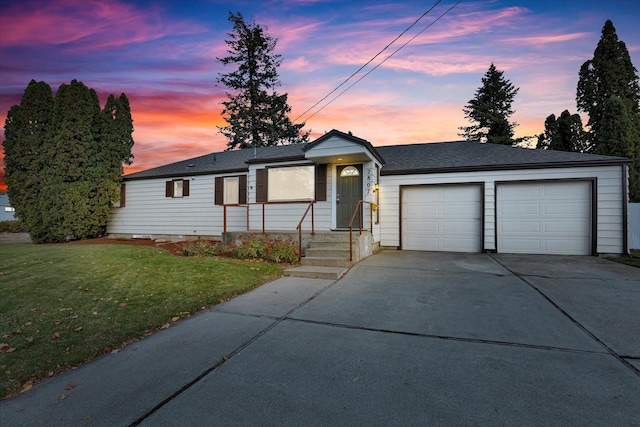 ranch-style house featuring a yard and a garage