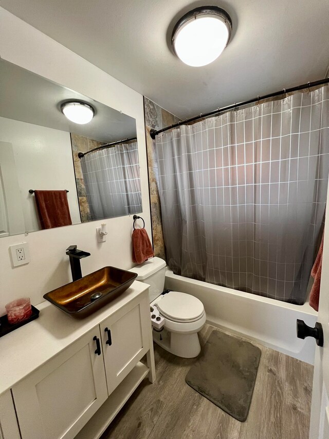 full bathroom featuring vanity, toilet, hardwood / wood-style flooring, and shower / bath combo with shower curtain