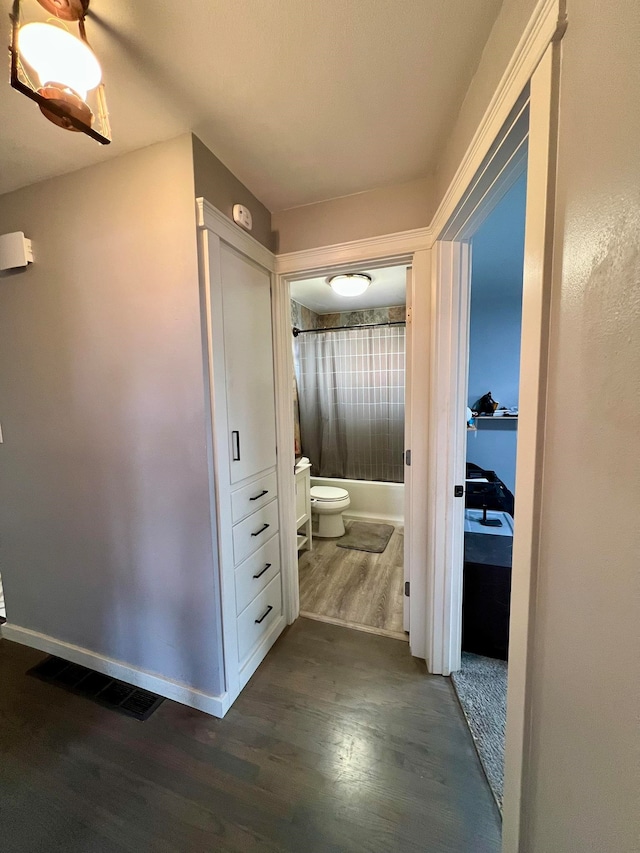 hallway with dark hardwood / wood-style flooring