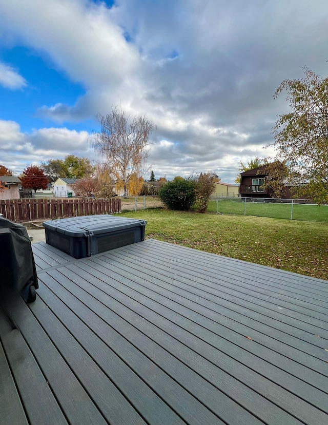 wooden terrace with a covered hot tub and a lawn