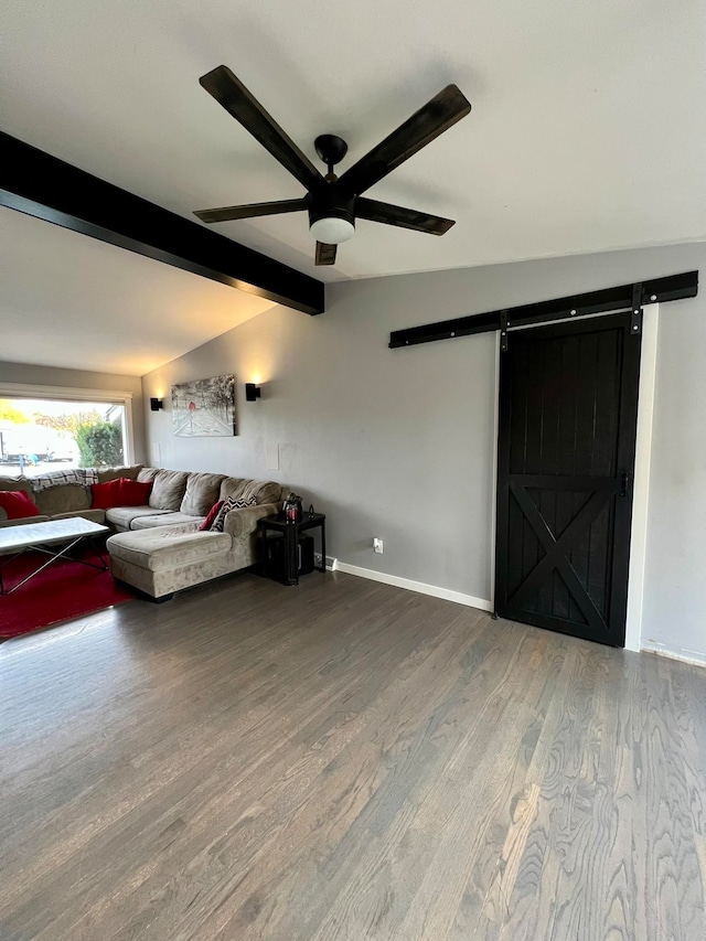 unfurnished living room featuring a barn door, vaulted ceiling with beams, hardwood / wood-style flooring, and ceiling fan