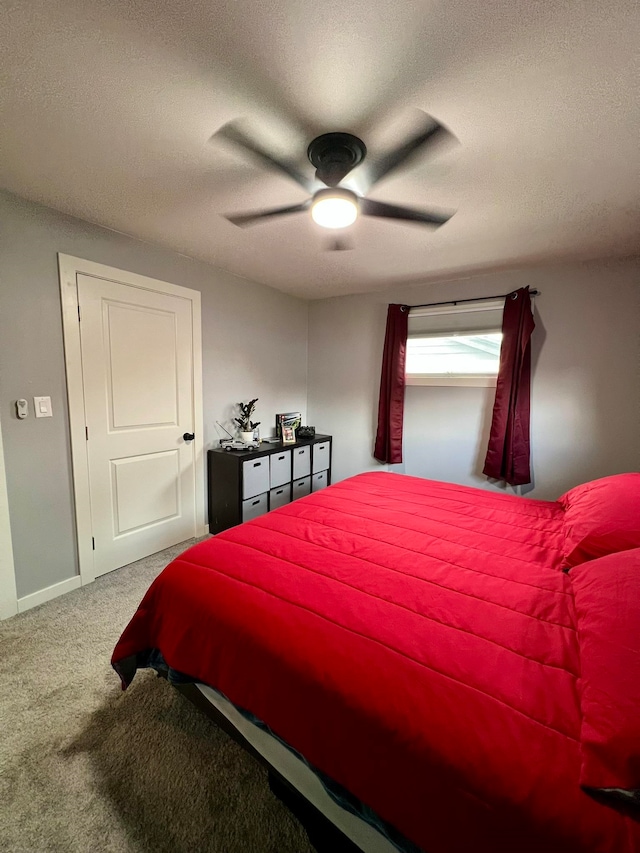 bedroom with a textured ceiling, carpet flooring, and ceiling fan