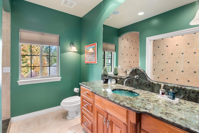 bathroom featuring toilet, vanity, and tile patterned flooring