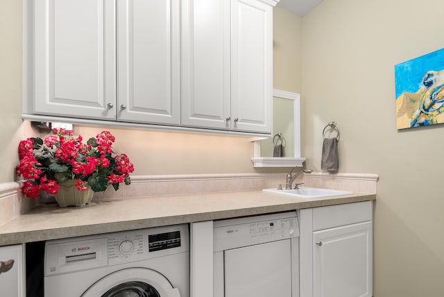 clothes washing area featuring washer / dryer, cabinets, and sink