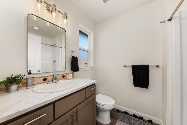 bathroom with vanity, a shower, wood-type flooring, and toilet