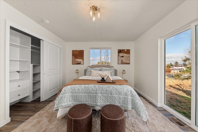 bedroom featuring dark wood-type flooring, a textured ceiling, and a closet