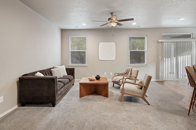 living room with a textured ceiling, light colored carpet, and ceiling fan