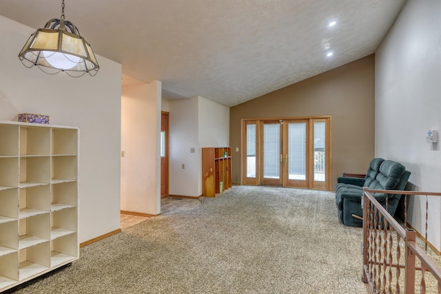 living room with french doors, a textured ceiling, vaulted ceiling, and light colored carpet