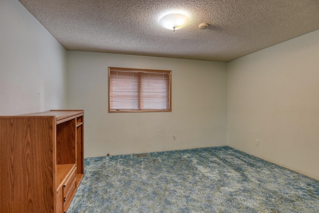 empty room featuring a textured ceiling and carpet floors