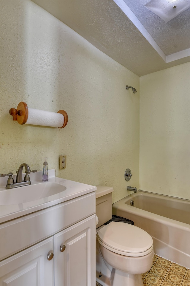 full bathroom with vanity, a textured ceiling, toilet, and bathing tub / shower combination