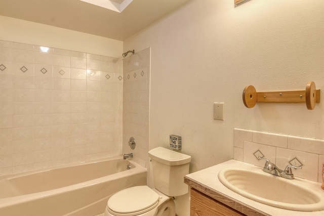 full bathroom featuring toilet, tiled shower / bath, and vanity