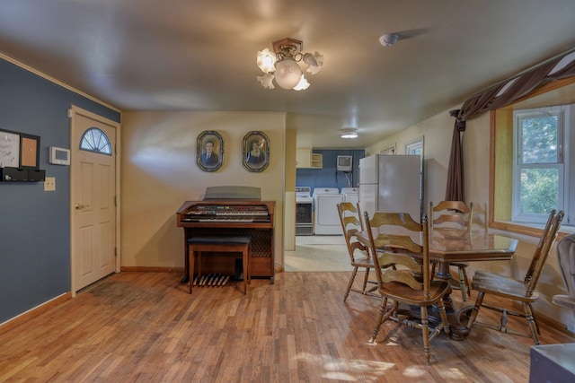 3224 E 28th Ave, Spokane, WA 99223 - dining space with baseboards, light wood finished floors, washer and dryer, and a chandelier