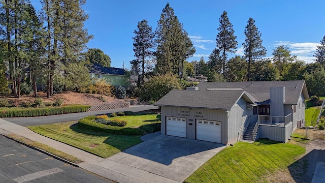 3224 E 28th Ave, Spokane, WA 99223 - ranch-style house with concrete driveway, stairway, a front lawn, and an attached garage
