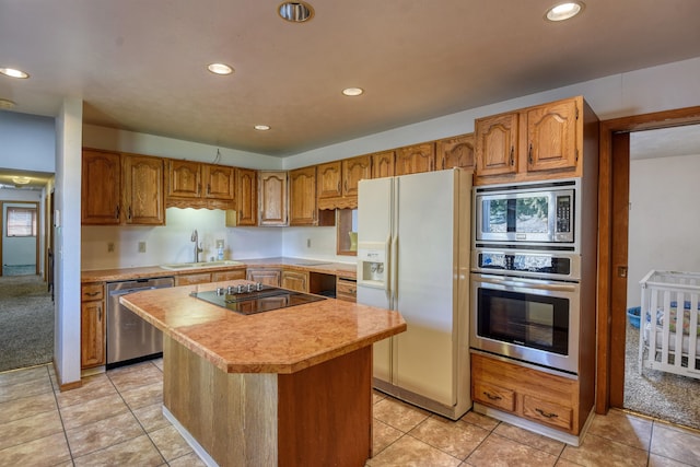 kitchen with light carpet, stainless steel appliances, sink, and a kitchen island