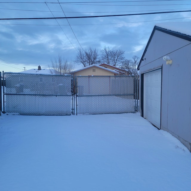 yard layered in snow featuring fence and an outbuilding