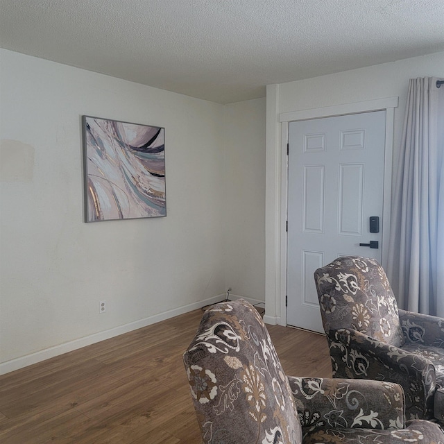 sitting room with dark hardwood / wood-style flooring and a textured ceiling