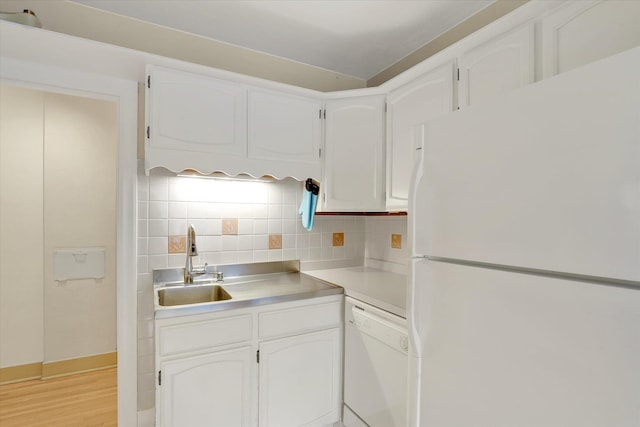 kitchen with decorative backsplash, light hardwood / wood-style floors, sink, white cabinets, and white appliances