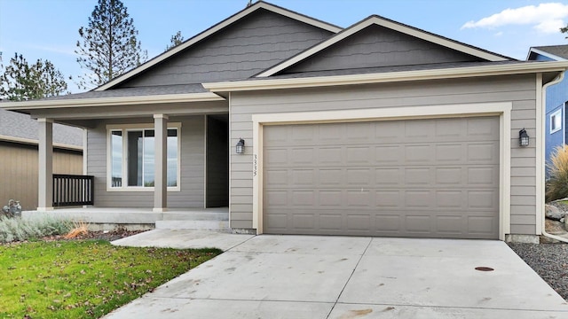 view of front of home with a porch, a garage, and concrete driveway