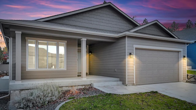 single story home featuring a porch, a garage, concrete driveway, and roof with shingles