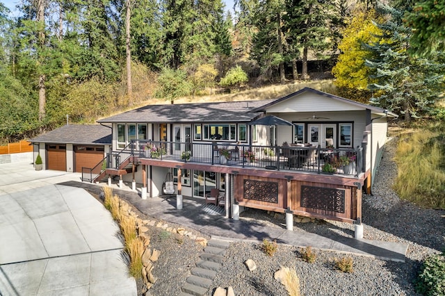 single story home with an outdoor structure, a deck, and a garage