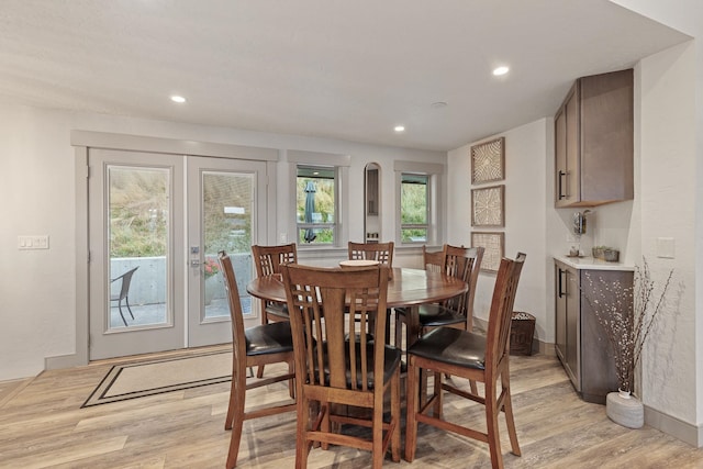 dining area with french doors and light hardwood / wood-style flooring