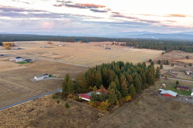 aerial view at dusk with a mountain view and a rural view