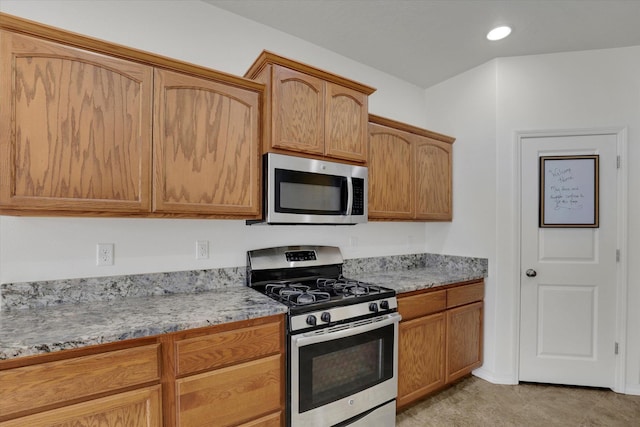 kitchen with appliances with stainless steel finishes and light stone countertops