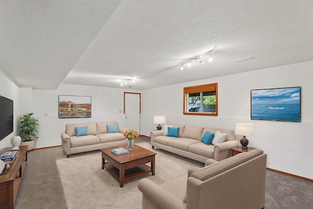 living room featuring track lighting, light carpet, and a textured ceiling