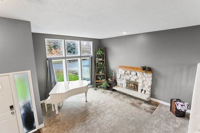 interior space with a stone fireplace and a textured ceiling