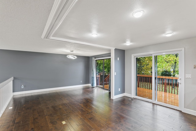 empty room with a textured ceiling and dark hardwood / wood-style floors