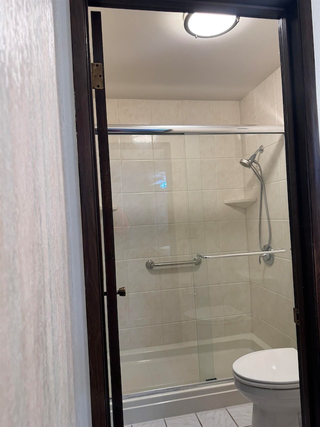 bathroom featuring toilet and an enclosed shower