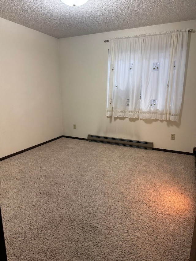 carpeted empty room featuring a baseboard heating unit and a textured ceiling