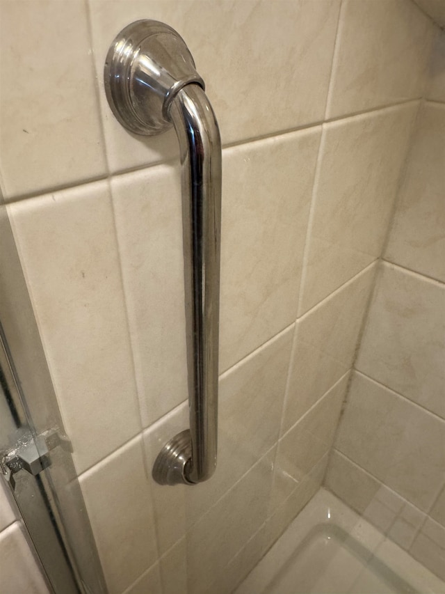 interior details featuring tiled shower