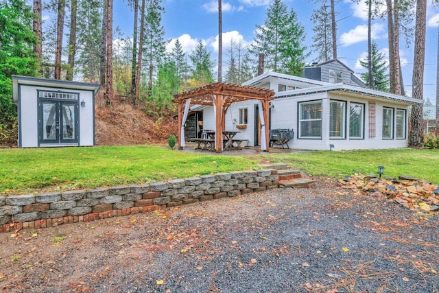 back of property with a lawn and a pergola