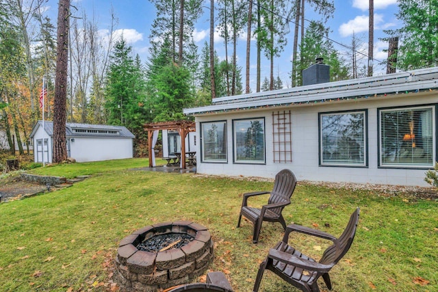 back of property with a shed, a fire pit, and a yard