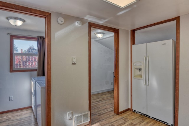 laundry area featuring washing machine and dryer and light wood-type flooring