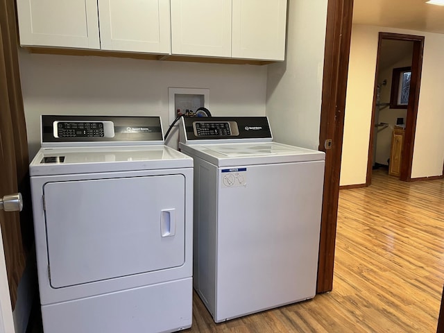 laundry area featuring cabinets, independent washer and dryer, and light wood-type flooring