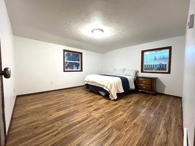 unfurnished bedroom featuring dark wood-type flooring and a textured ceiling