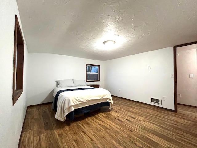 bedroom with hardwood / wood-style flooring and a textured ceiling