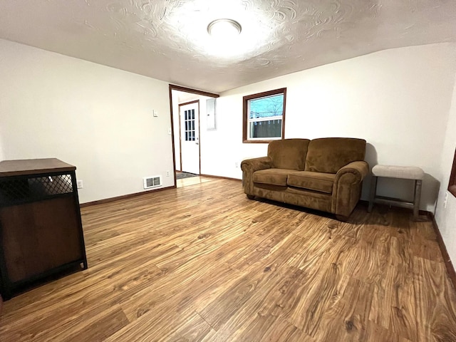 living room with wood-type flooring and a textured ceiling