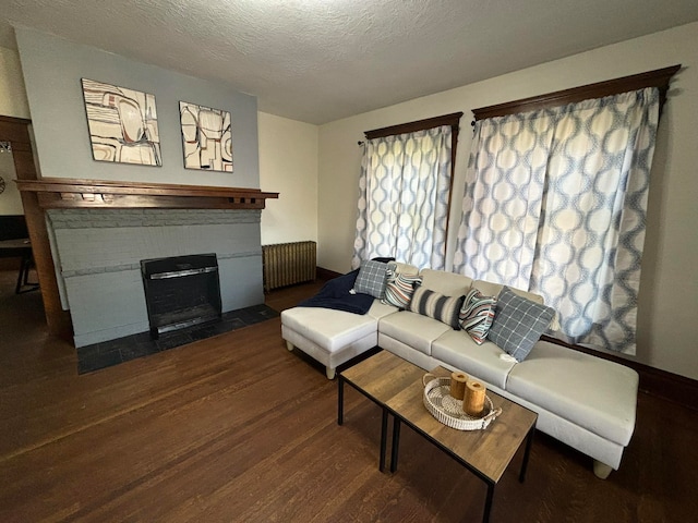 living room with radiator heating unit, dark hardwood / wood-style flooring, and a textured ceiling