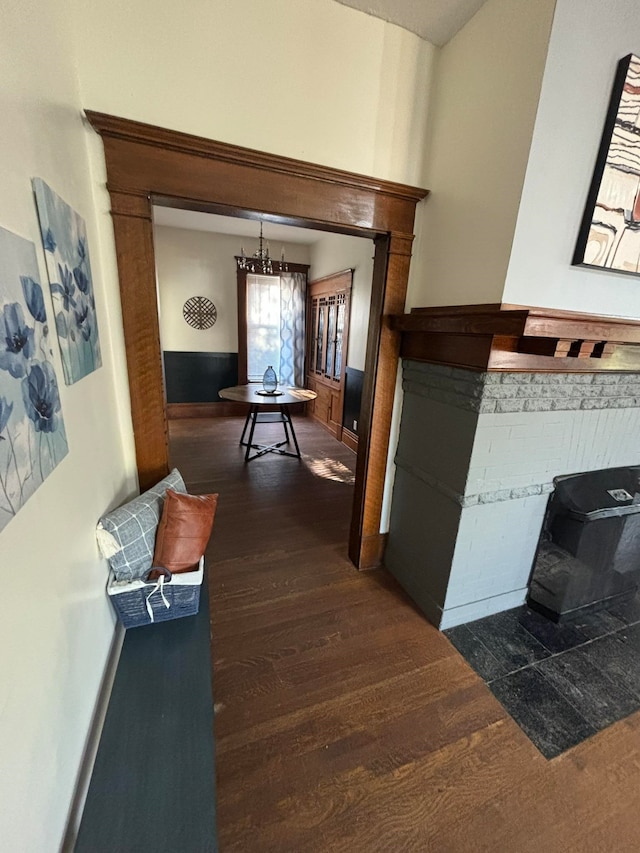 corridor featuring a notable chandelier and dark hardwood / wood-style flooring