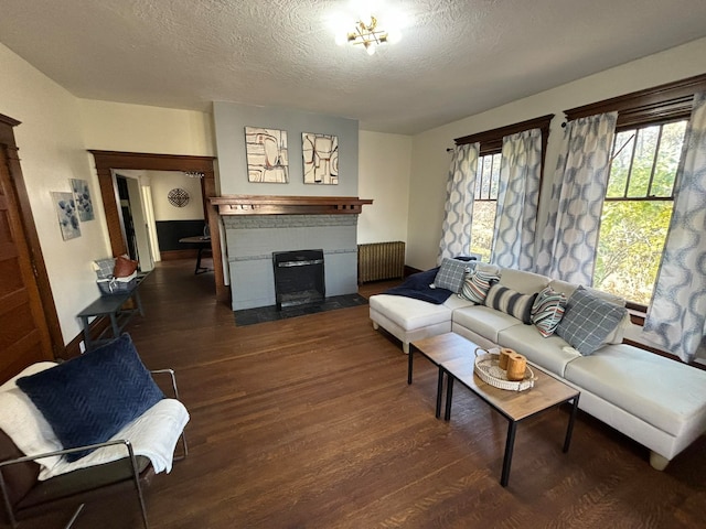 living room with radiator heating unit, dark hardwood / wood-style floors, and a textured ceiling