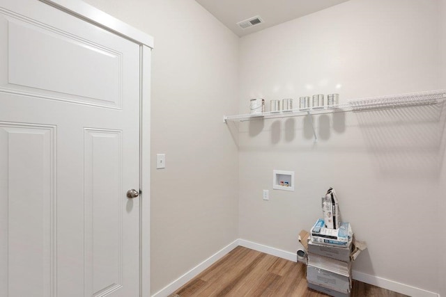 clothes washing area with hookup for a washing machine and hardwood / wood-style flooring