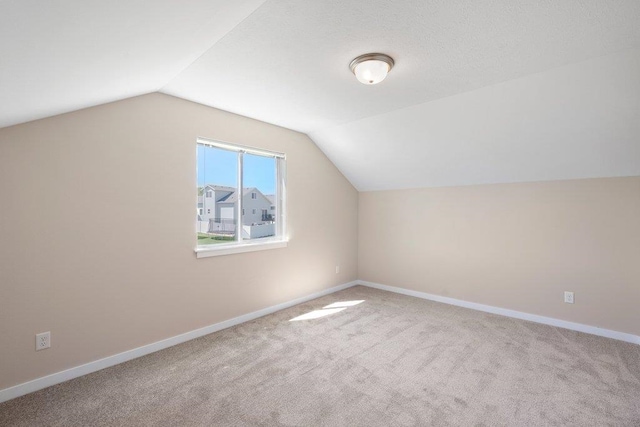 bonus room featuring light carpet and vaulted ceiling