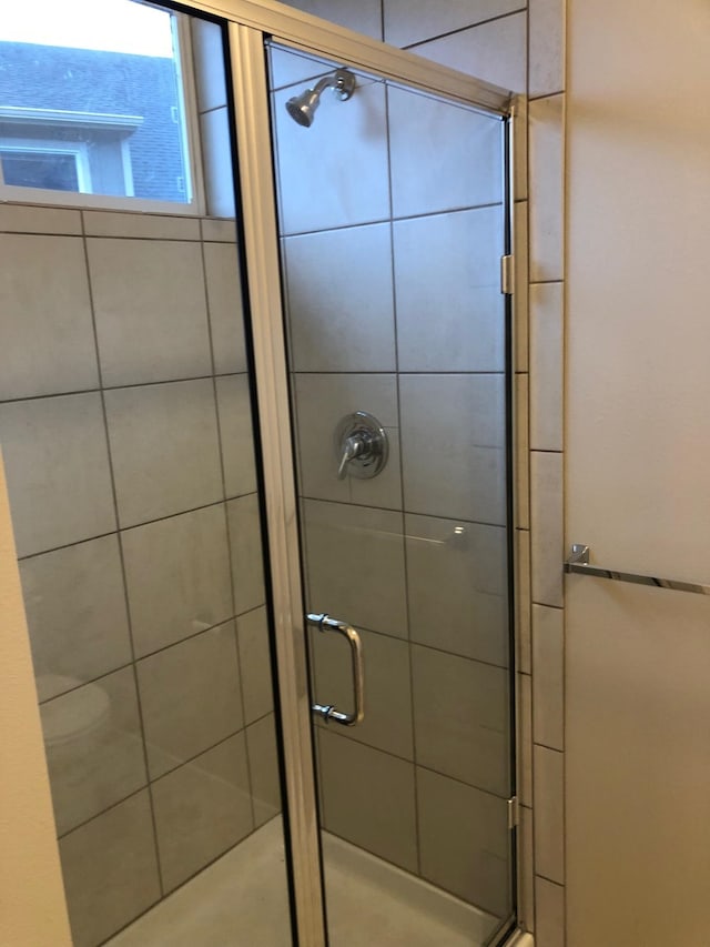 bathroom featuring a shower with door