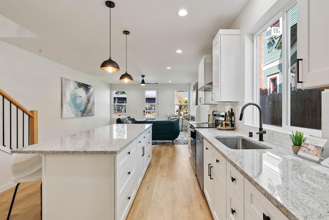 kitchen featuring white cabinetry, a wealth of natural light, sink, and decorative light fixtures